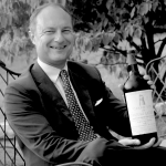 Portrait of Frédéric Engerer with a bottle of Château Latour