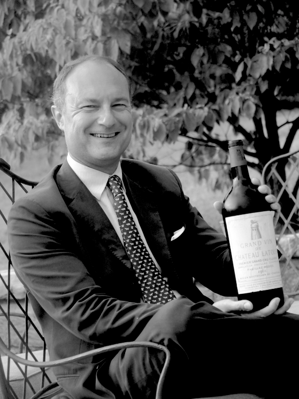 Portrait of Frédéric Engerer with a bottle of Château Latour